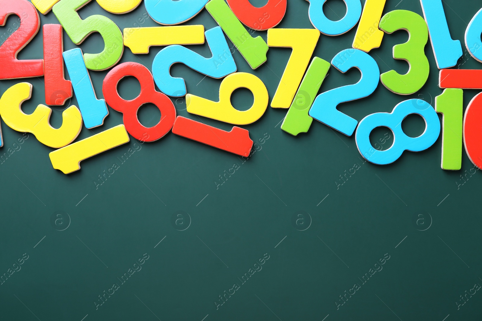 Photo of Colorful numbers on green background, flat lay. Space for text