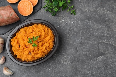 Flat lay composition with mashed sweet potatoes on grey background, space for text