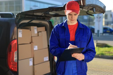 Photo of Courier with clipboard near delivery van outdoors, space for text