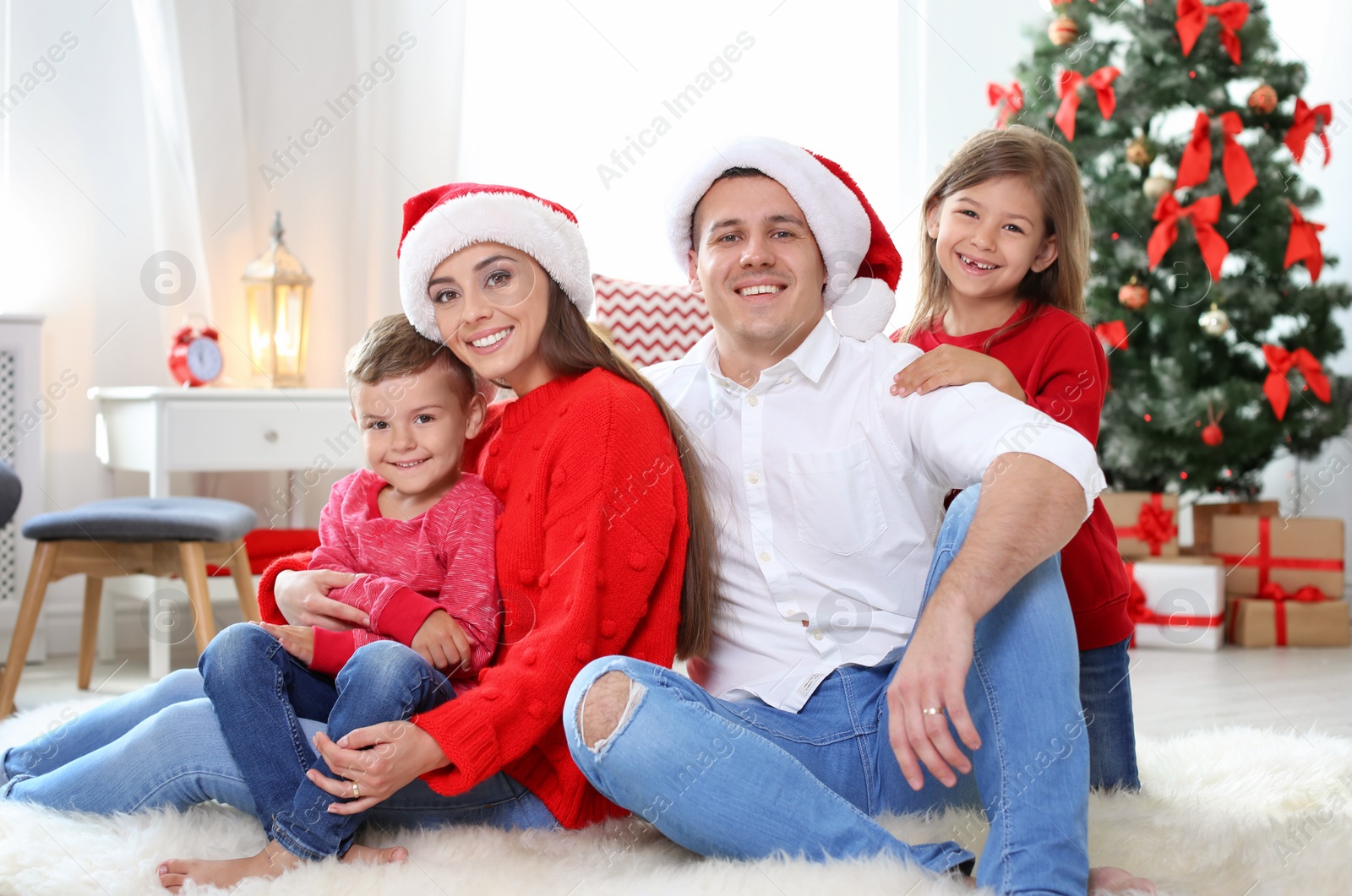 Photo of Happy parents celebrating Christmas with children at home