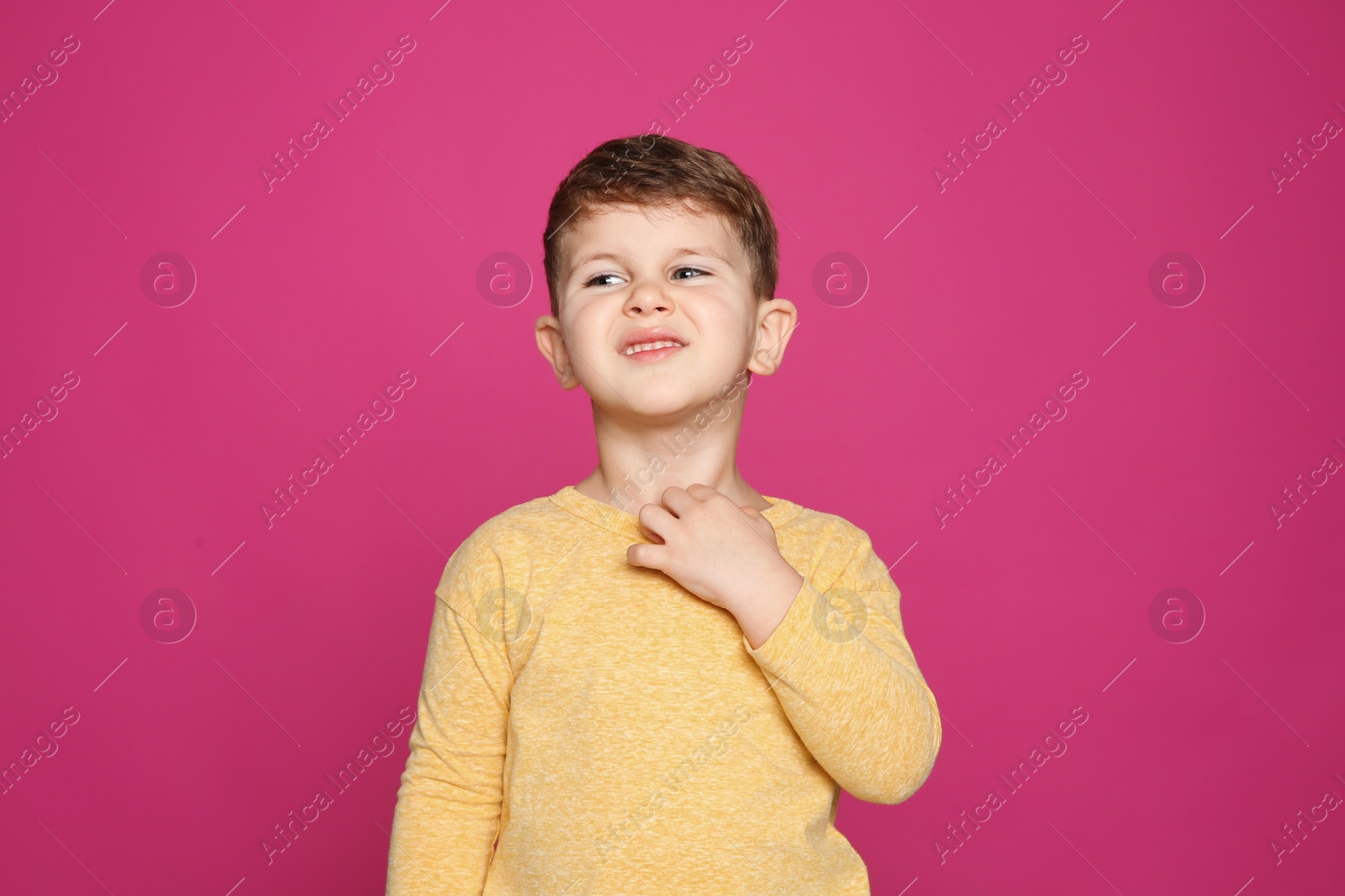 Photo of Little boy scratching neck on color background. Annoying itch