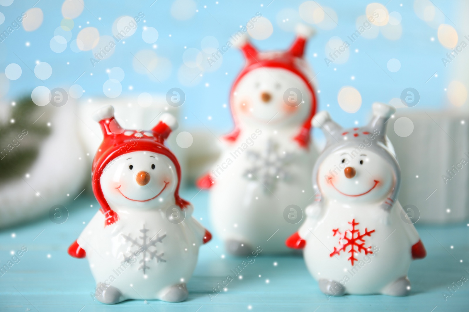 Photo of Three decorative snowmen on light blue table