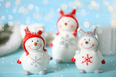 Photo of Three decorative snowmen on light blue table