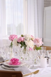 Stylish table setting with beautiful peonies in dining room, space for text