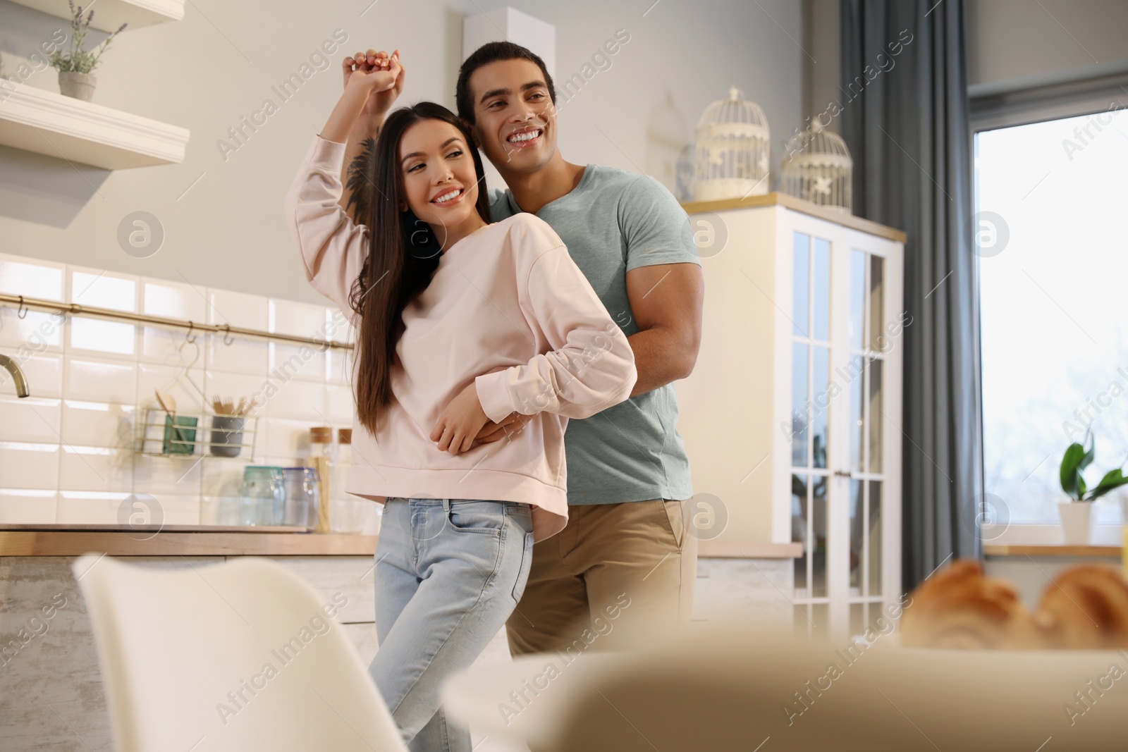 Photo of Lovely young interracial couple dancing at home