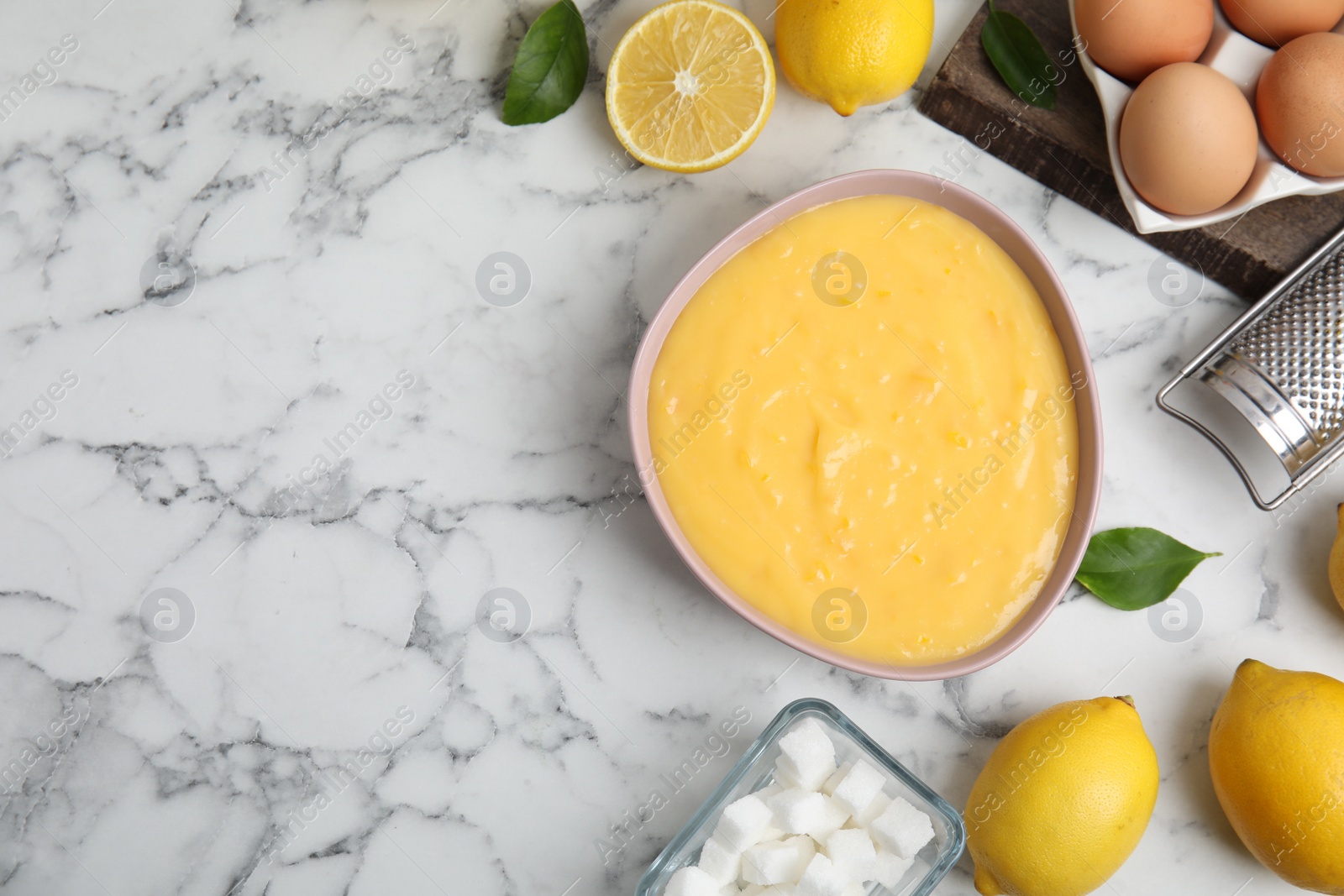 Photo of Delicious lemon curd and fresh fruits on white marble table, flat lay. Space for text