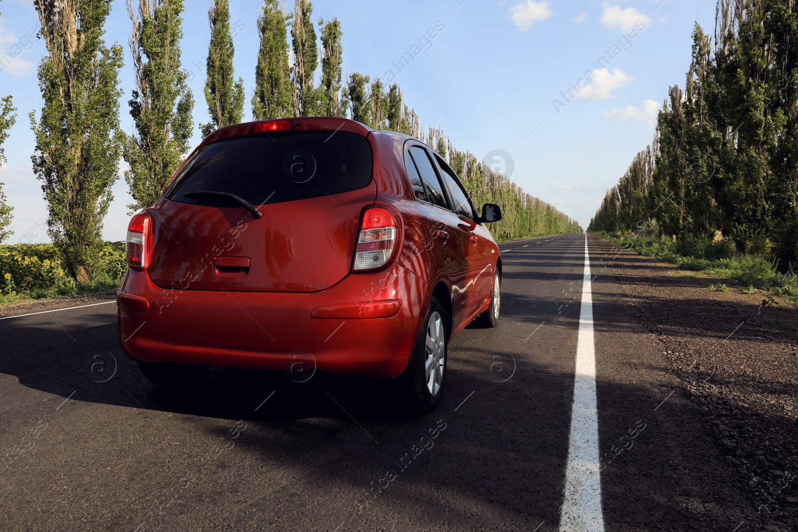 Photo of Red car on asphalt road in countryside