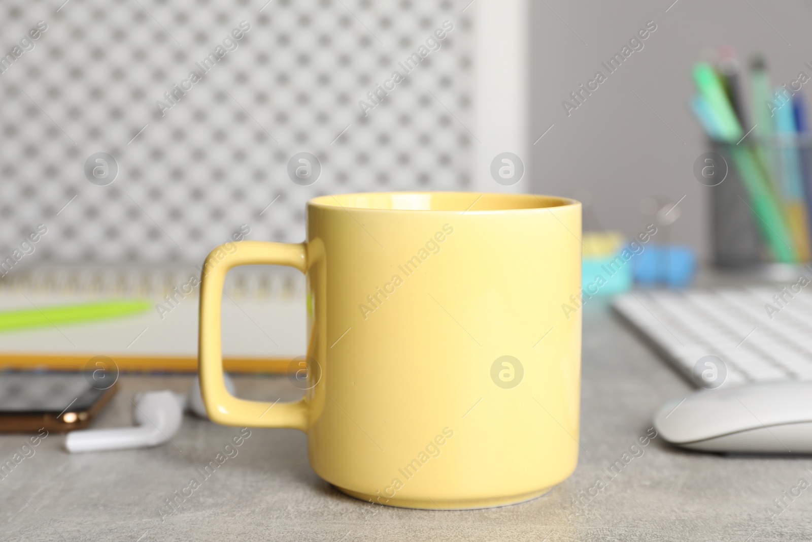 Photo of Coffee Break at workplace. Cup of hot drink on grey table