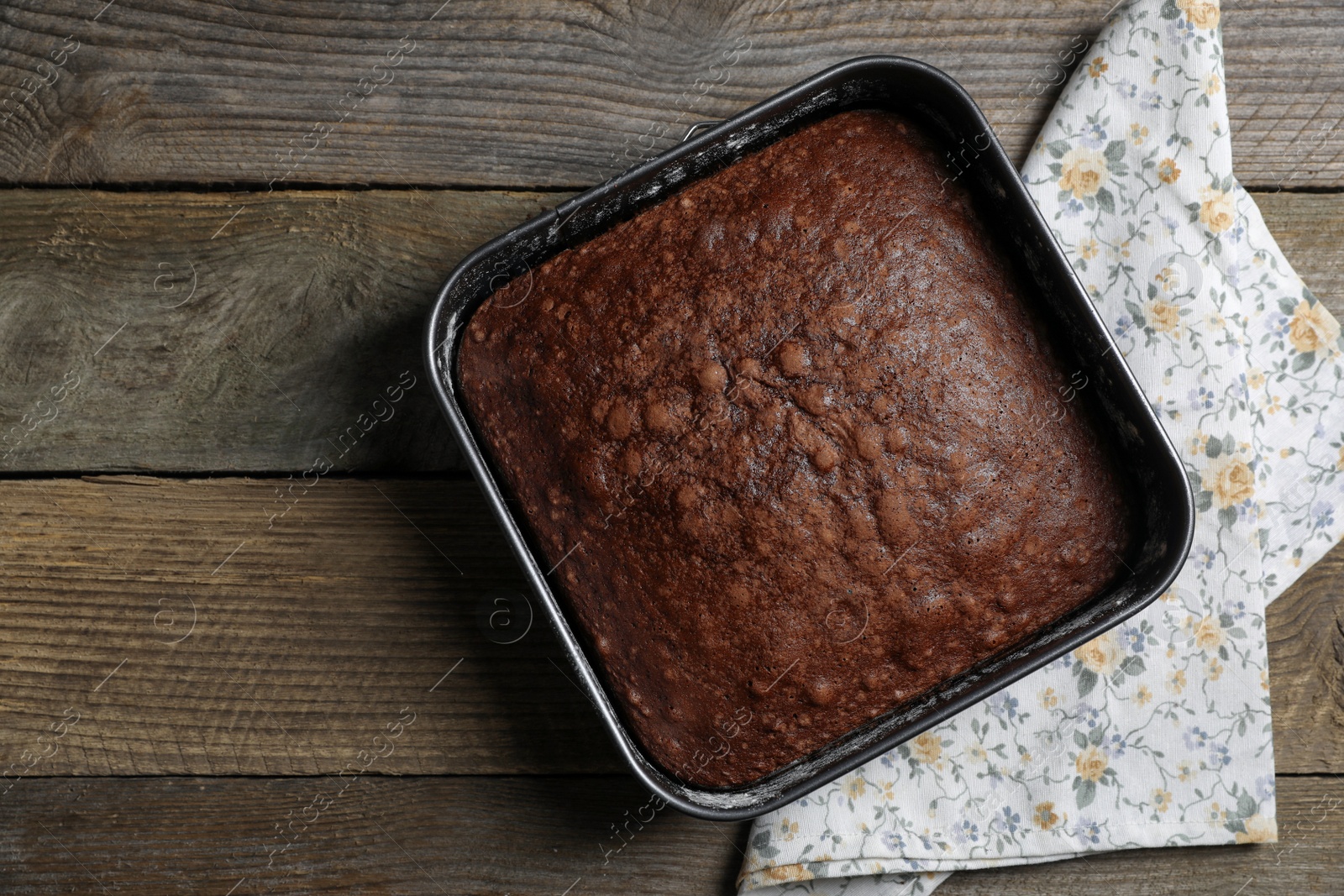 Photo of Homemade chocolate sponge cake on wooden table, top view. Space for text