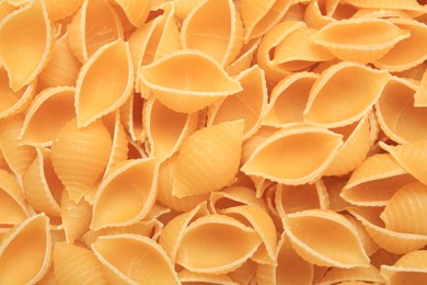 Raw conchiglie pasta as background, top view