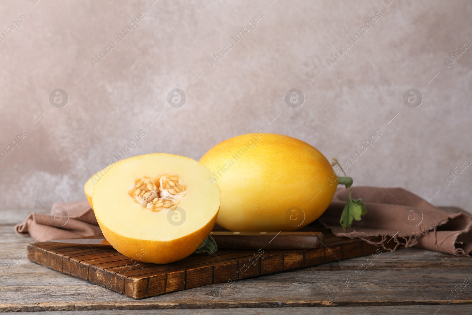 Photo of Sliced ripe melon on wooden table against color background