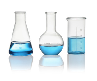 Photo of Different laboratory glassware with light blue liquid isolated on white