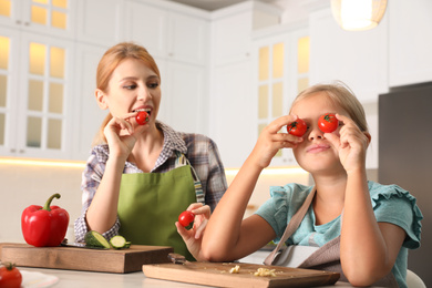 Mother and daughter cooking salad together in kitchen