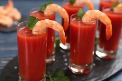 Photo of Shrimp cocktail with tomato sauce served on slate board