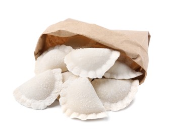 Photo of Paper bag of raw dumplings (varenyky) with tasty filling on white background