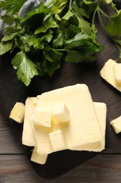 Photo of Tasty butter and parsley on wooden table, top view