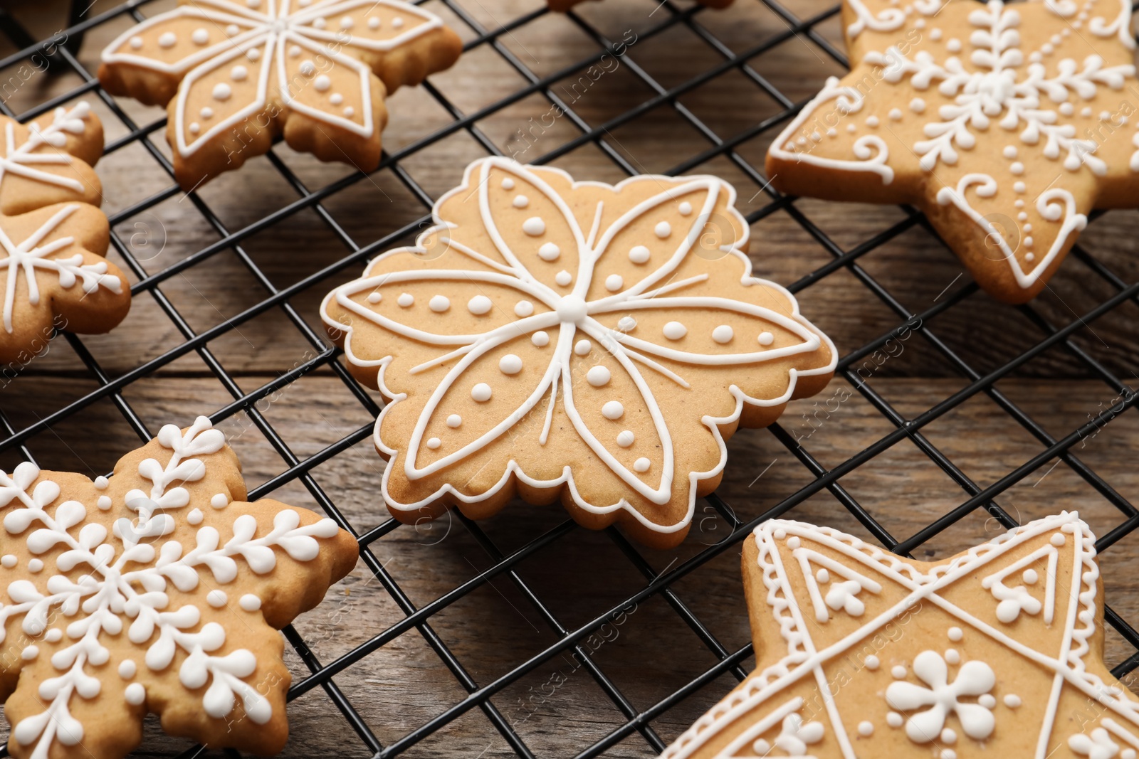Photo of Tasty Christmas cookies on cooling rack, closeup