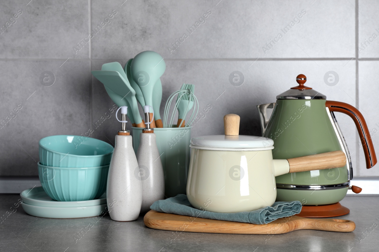 Photo of Set of different cooking utensils on grey countertop in kitchen