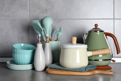 Set of different cooking utensils on grey countertop in kitchen