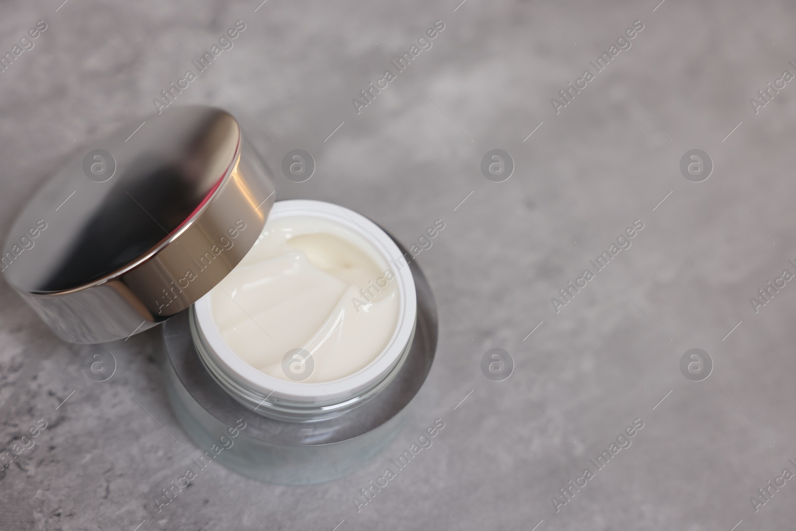 Photo of Body cream on grey table, space for text