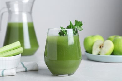 Photo of Glass of fresh celery juice on light marble table