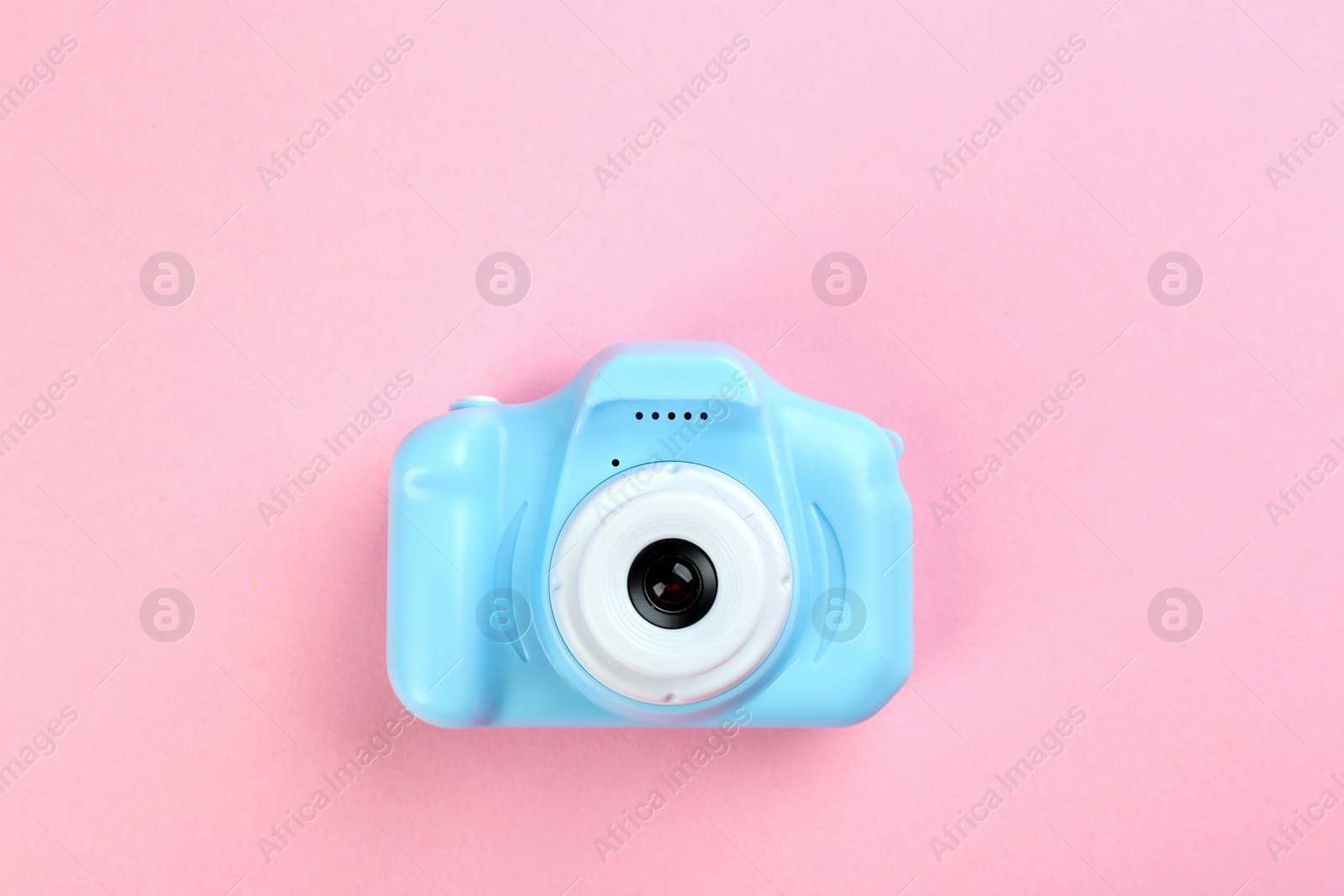 Photo of Light blue toy camera on pink background, top view