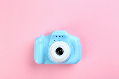 Photo of Light blue toy camera on pink background, top view