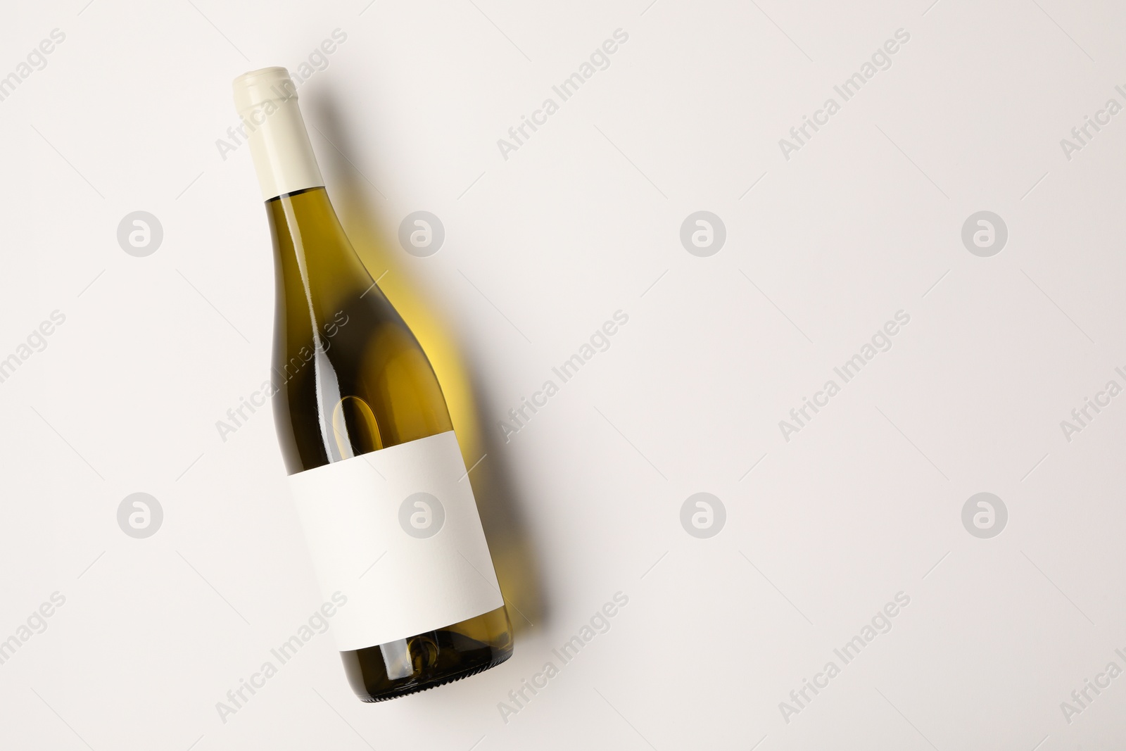 Photo of Bottle of tasty wine on white background, top view. Space for text