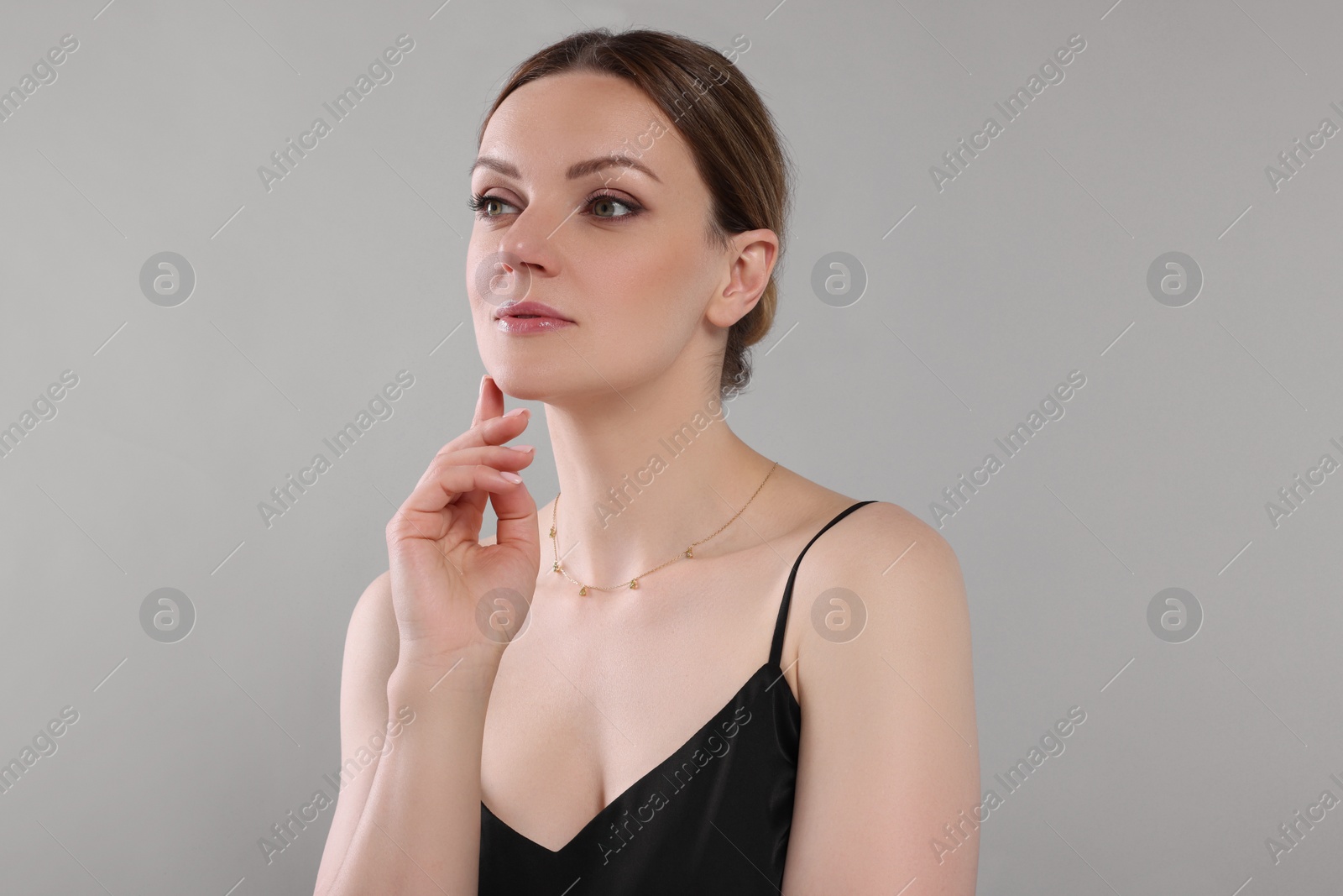 Photo of Beautiful woman with elegant necklace on light grey background