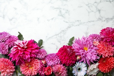 Flat lay composition with beautiful dahlia flowers on white marble background. Space for text
