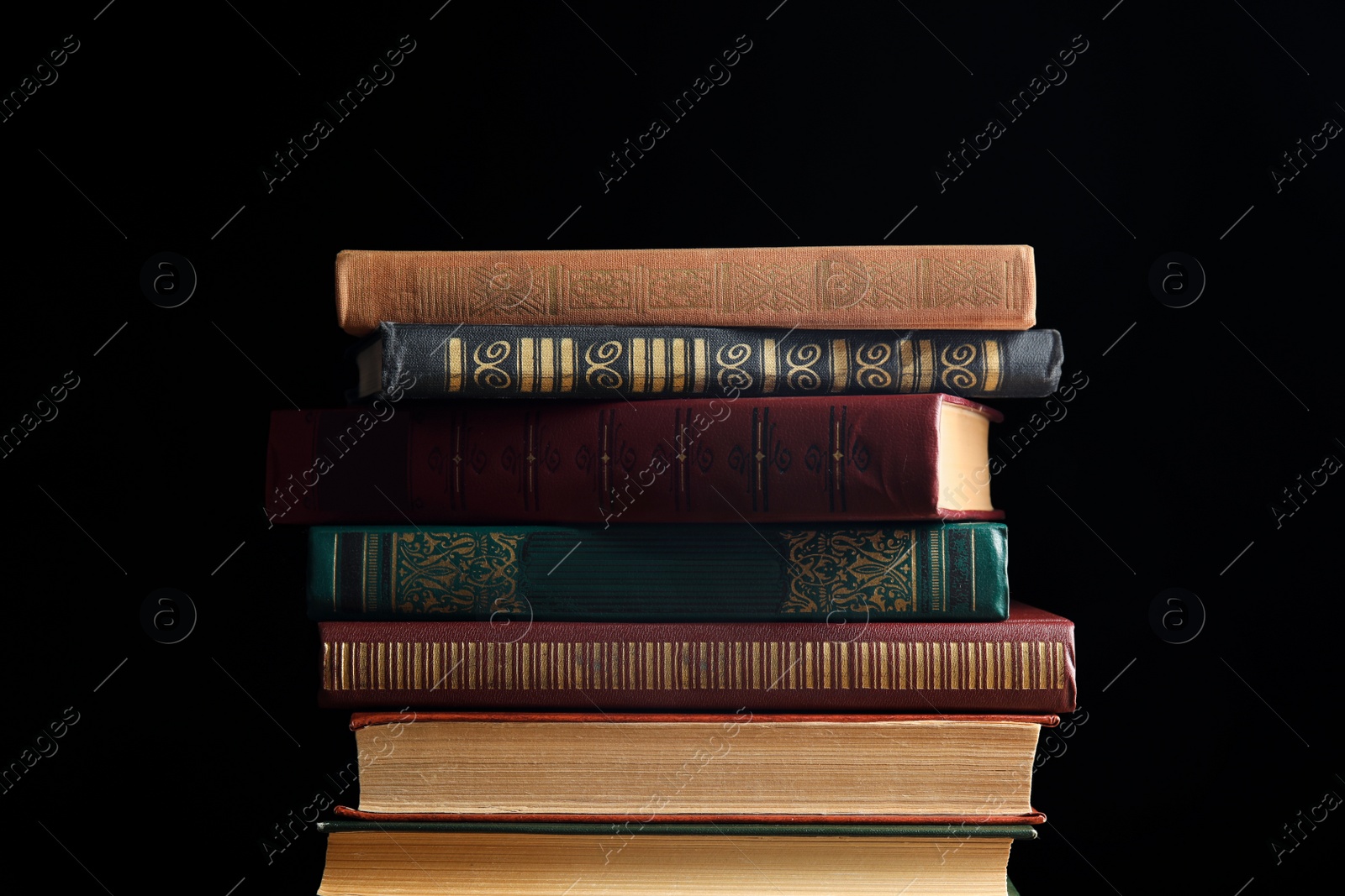 Photo of Collection of different books on dark background