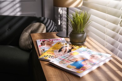 Photo of Different lifestyle magazines on chest of drawers indoors