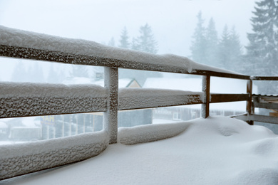Photo of Cottage balcony covered with snow. Winter beauty