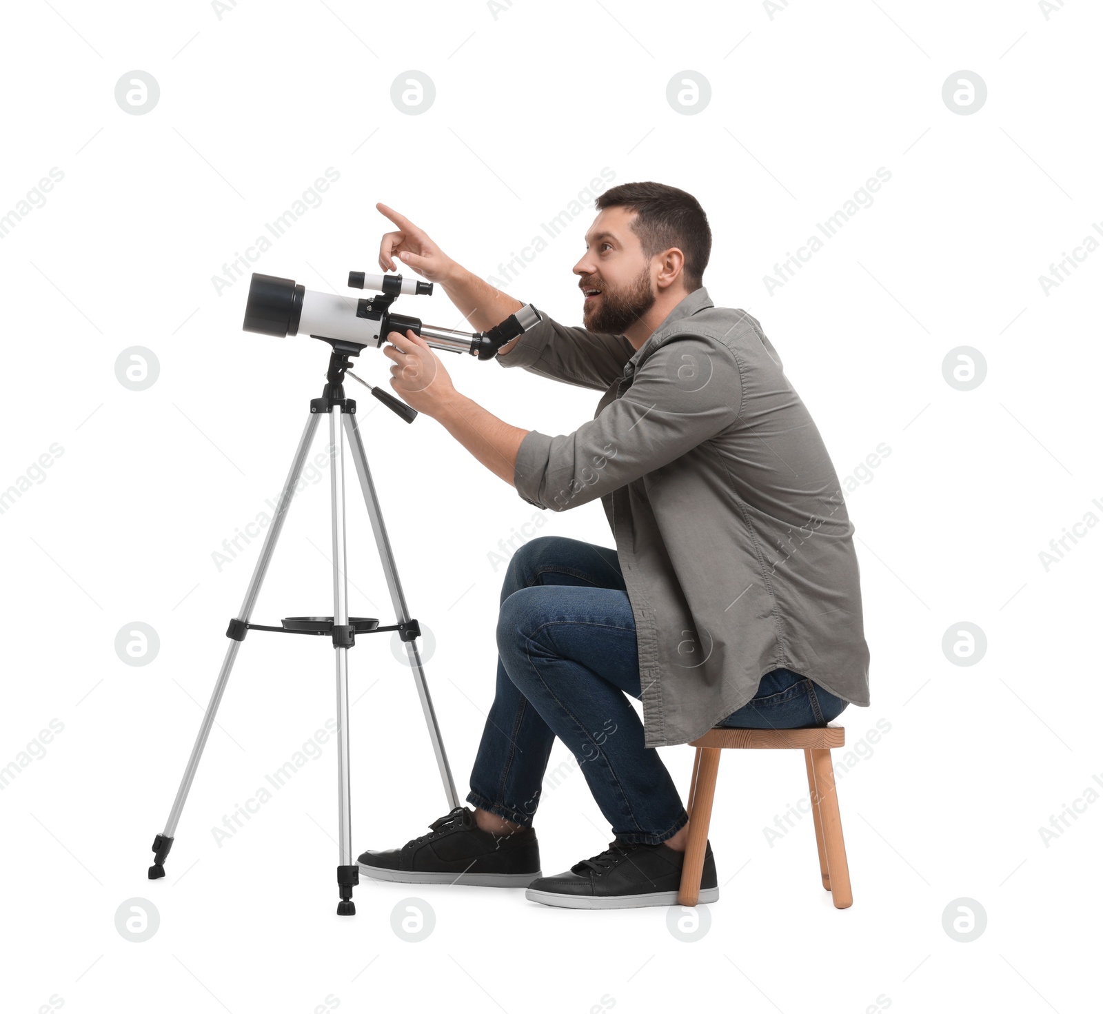 Photo of Excited astronomer with telescope pointing at something on white background