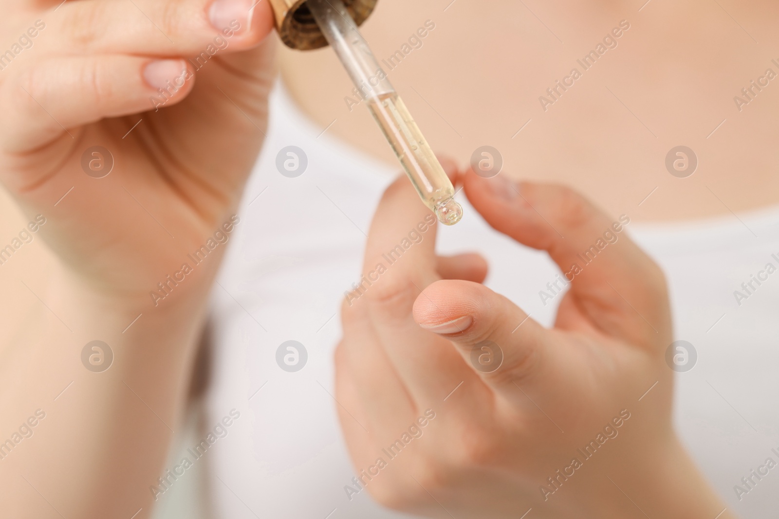 Photo of Woman applying essential oil onto hand, closeup