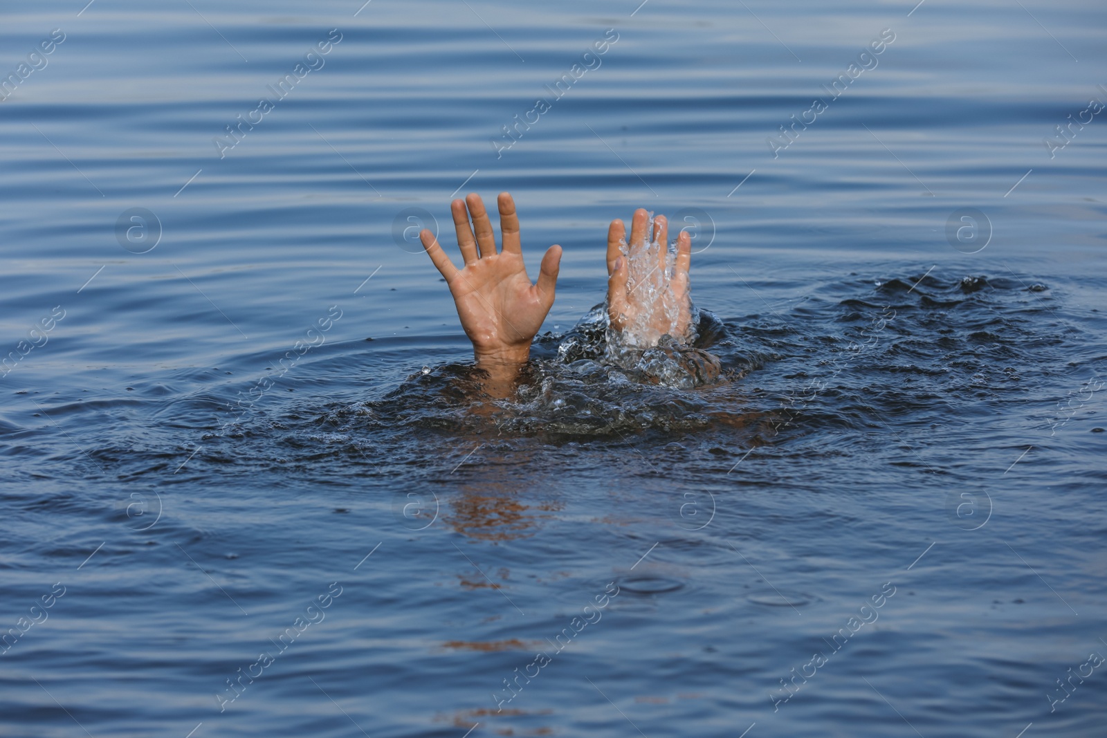 Photo of Drowning man reaching for help in sea, closeup