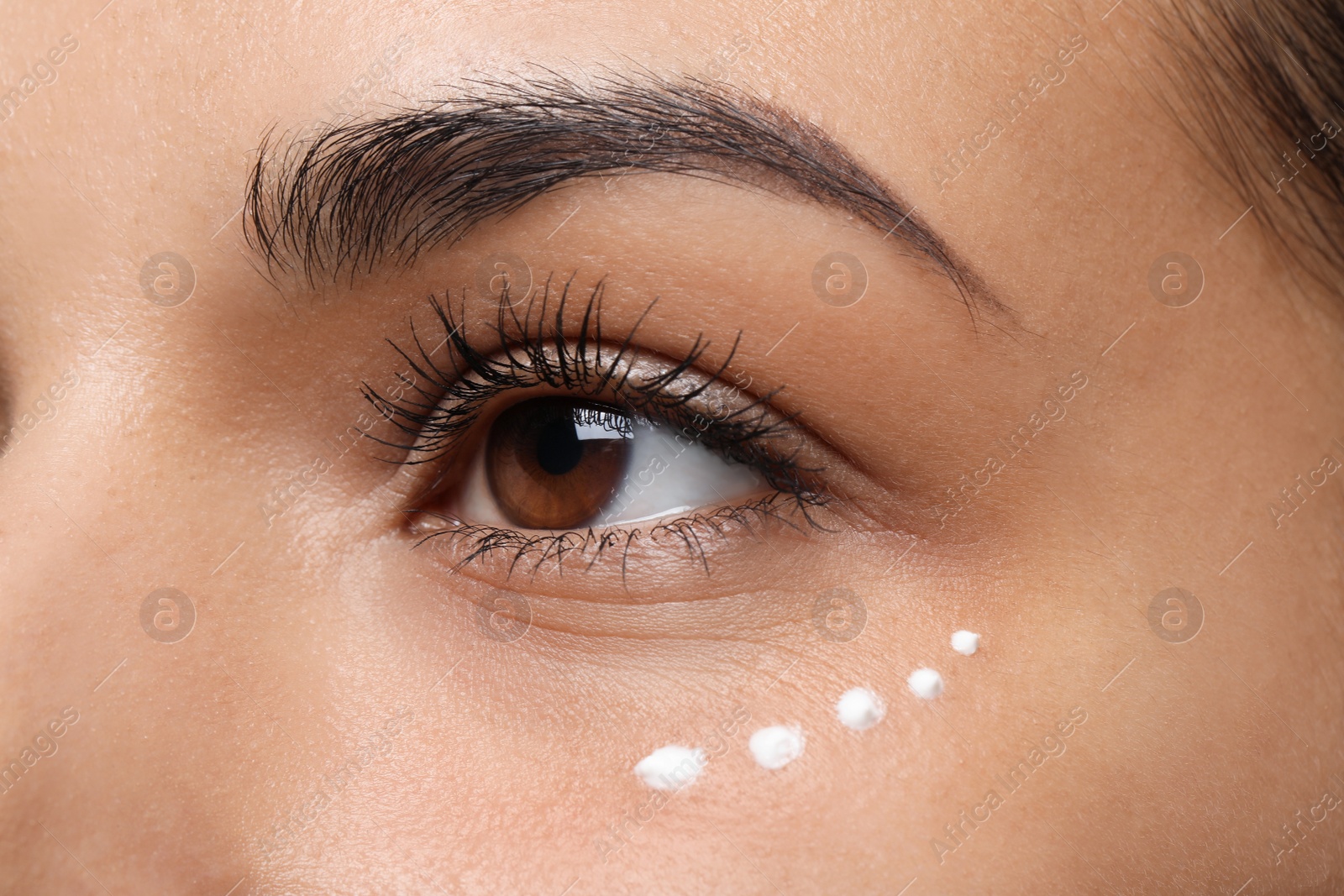 Photo of Woman with eye cream on white background, closeup. Skin care