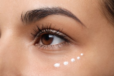 Photo of Woman with eye cream on white background, closeup. Skin care