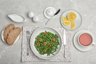 Photo of Flat lay composition with plate of fresh green bean salad on table