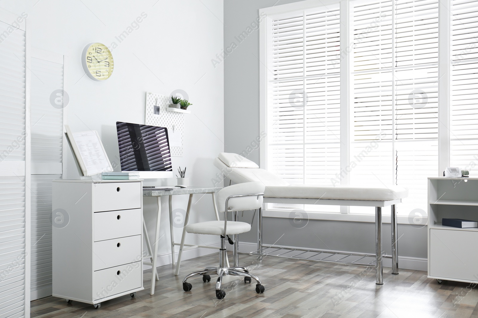 Photo of Modern medical office interior with computer and examination table