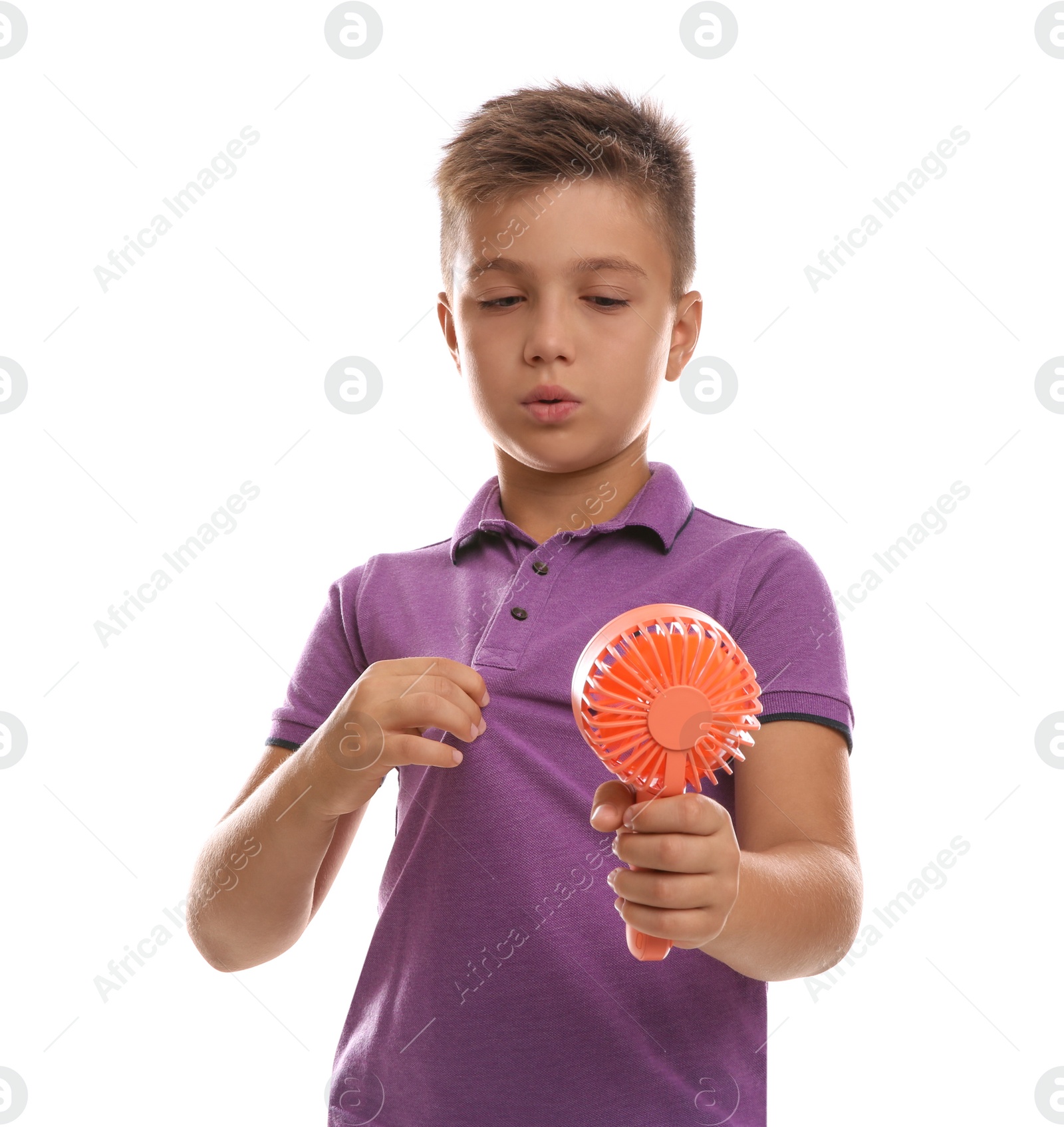 Photo of Little boy with portable fan suffering from heat on white background. Summer season