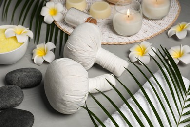 Photo of Spa bags, stones and orchid flowers on light gray table