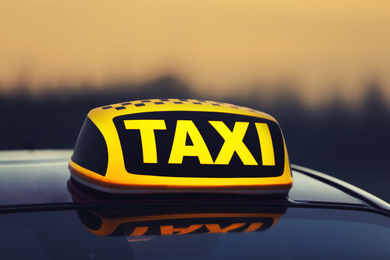 Photo of Taxi car with yellow roof sign outdoors, closeup