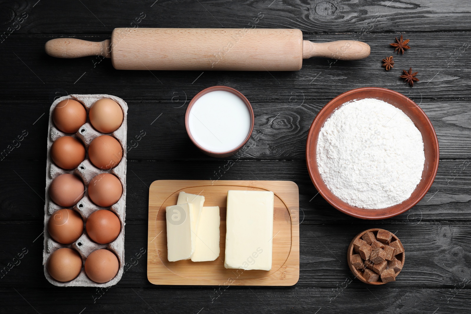 Photo of Cooking utensils and ingredients on black wooden table, flat lay