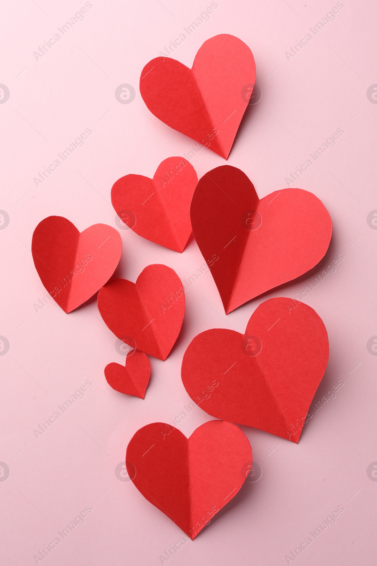 Photo of Paper hearts on pink background, flat lay