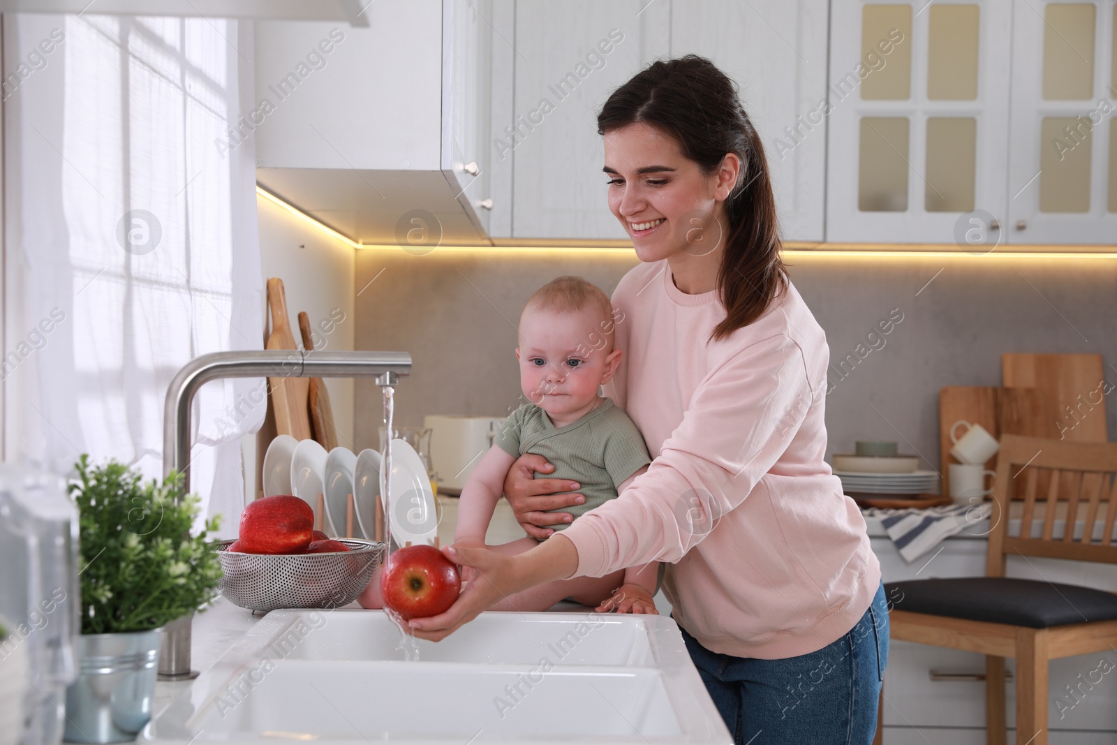 Photo of Mother and her cute little baby spending time together in kitchen