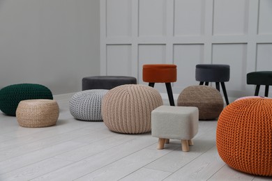 Different stylish poufs and ottomans in room