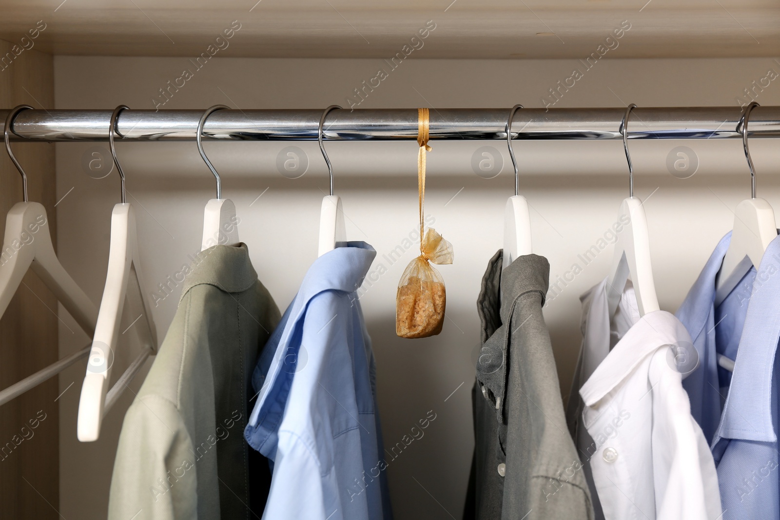 Photo of Scented sachet and clothes hanging in wardrobe