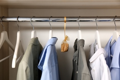 Scented sachet and clothes hanging in wardrobe