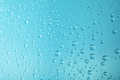 Photo of Many clean water drops on color background